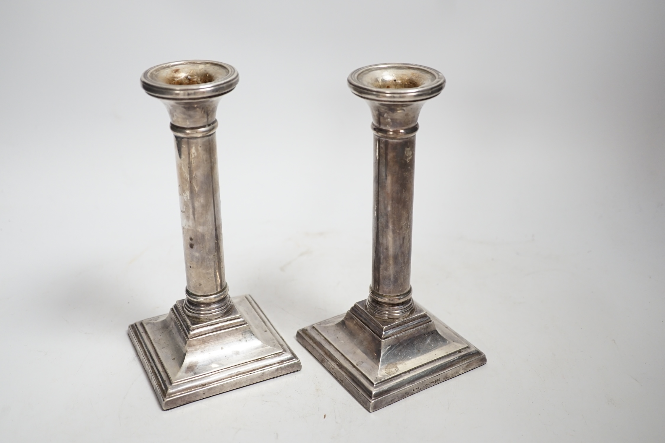 A pair of modern silver mounted candlesticks, 17cm, weighted, together with an Edwardian silver mounted cut glass scent bottle.